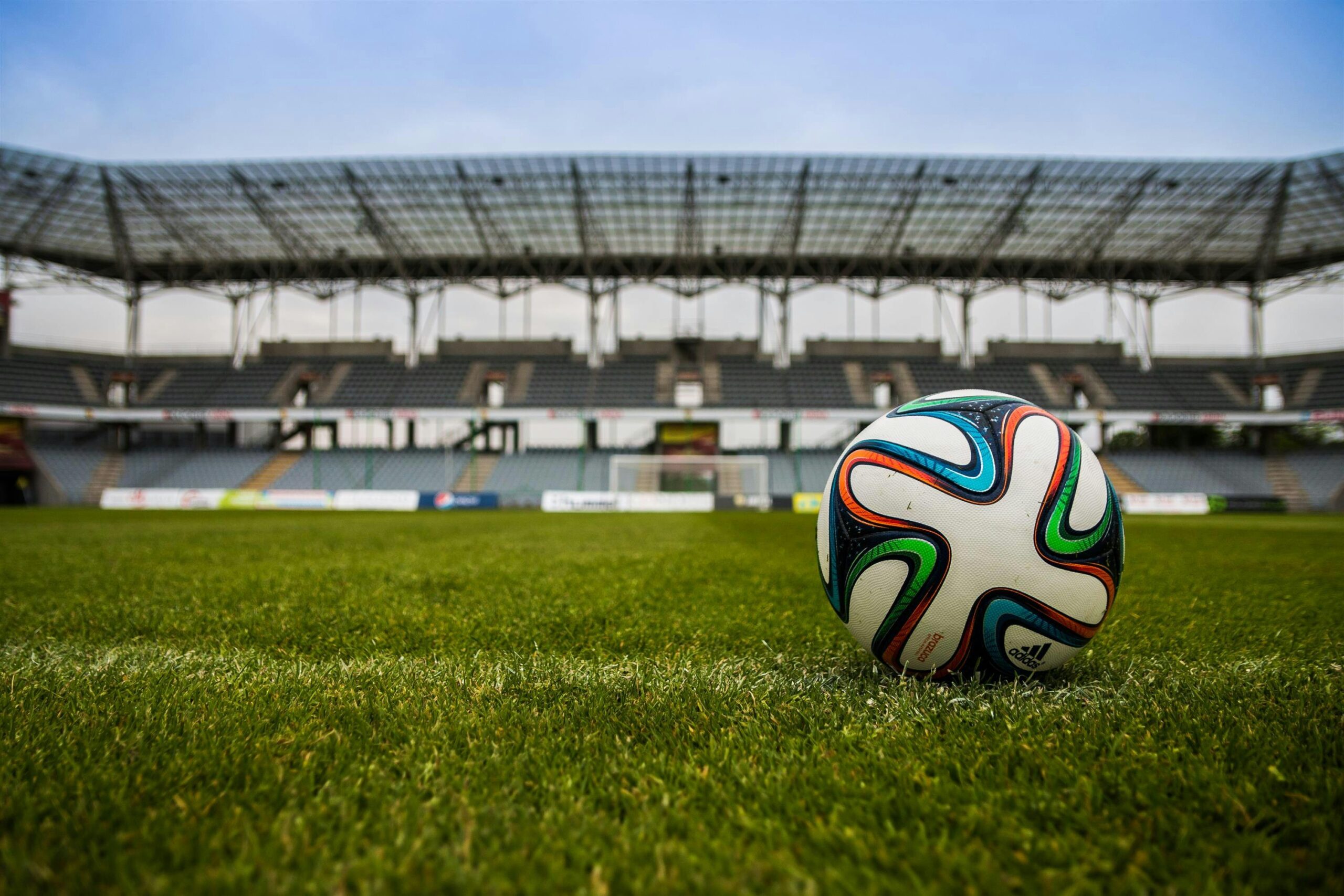 Sample Campaign 1 Close-up of a soccer ball on a lush grass field with an empty stadium in the background.